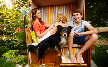 Verreisen mit Hund: Familie mit Tieren im Strandkorb